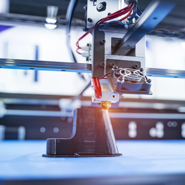 Detailansicht eines 3D-Druckers mit sichtbarem Druckkopf und Kabeln.
